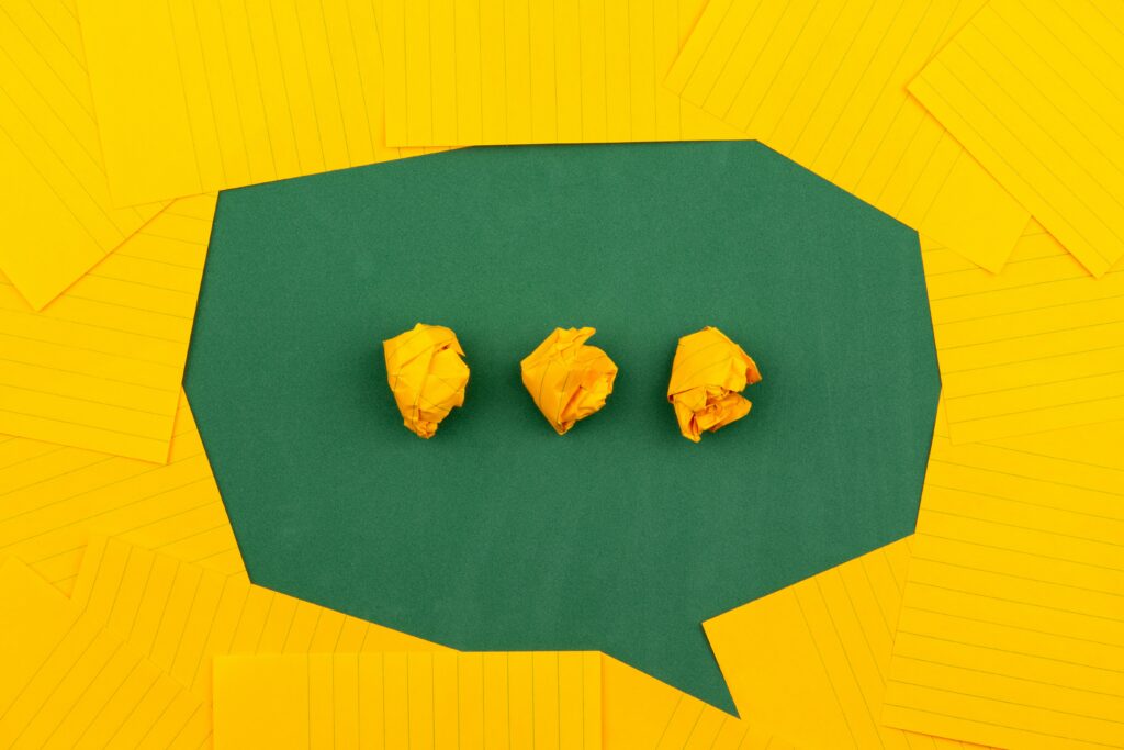 Three yellow crumpled pieces of paper depicting WhatsApp activity in a speech bubble on a yellow background.